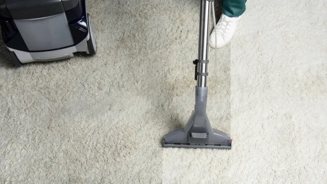 a person's legs and a vacuum cleaner