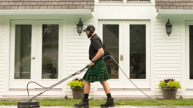 a person in a kilt holding a pool stick