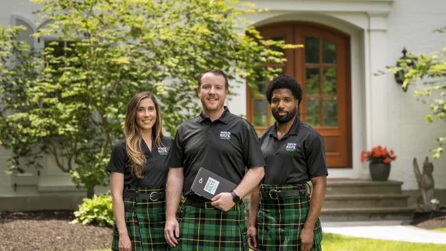 James Doyle et al. posing for a photo with a kilt