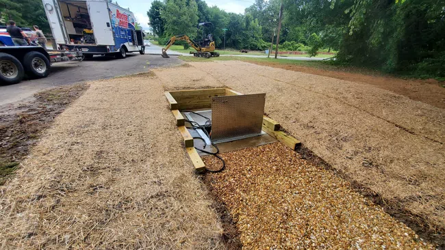 a pile of dirt next to a truck and a pile of dirt