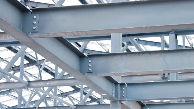 Close-up view of steel structure beams and trusses in modern industrial building construction.