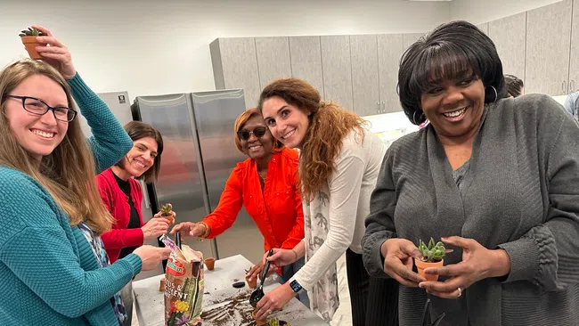 a group of people standing around a table with food on it