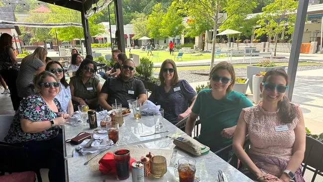 a group of people sitting at a table outside