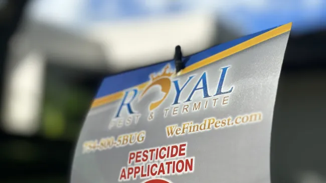 Royal Pest & Termite pesticide application warning sign advising to keep off treated area outdoors.