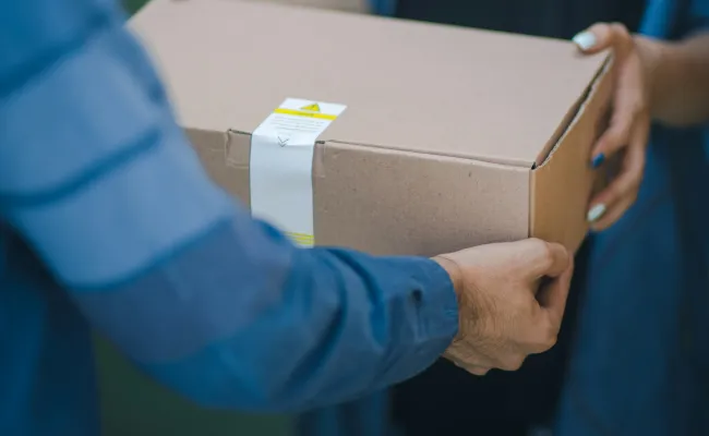 a person handing a box to another woman