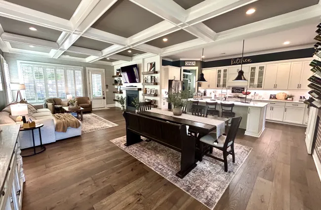 Spacious open-concept living room and kitchen with hardwood floors, coffered ceiling, and modern farmhouse decor.
