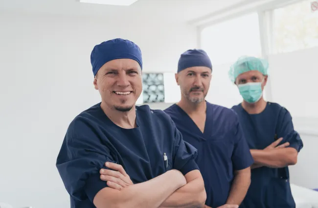 a group of people wearing surgical scrubs and posing for the camera