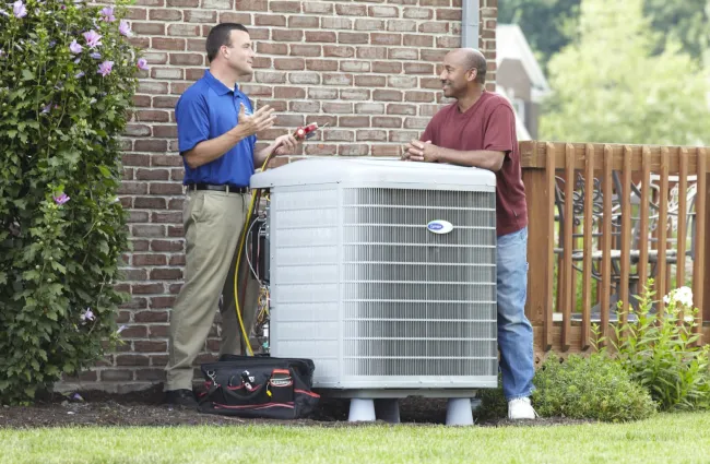 a couple of men standing next to a solar panel