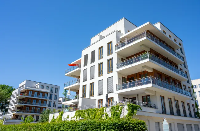 a building with balconies and trees in the front