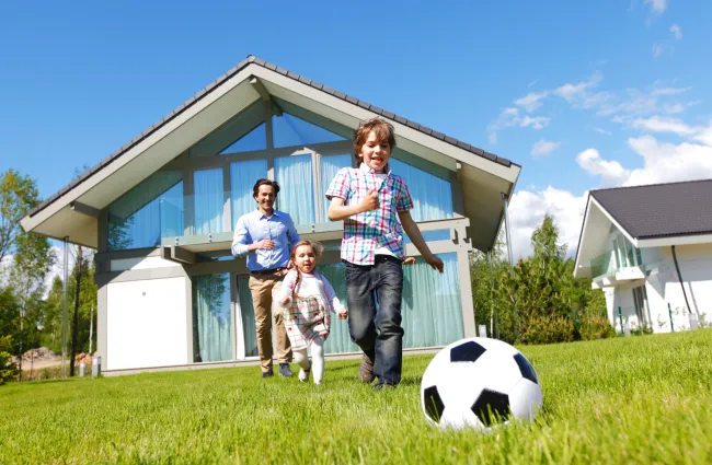 a family standing in front of a house with a football ball