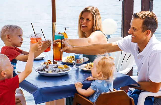 a group of people sitting at a table eating food