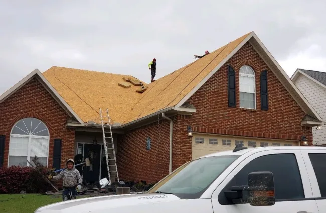 a person on a ladder on a roof of a house