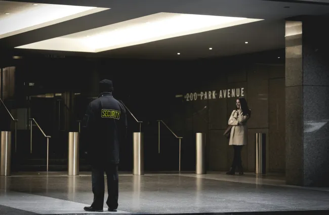 a man and woman standing in a large room with columns and a sign