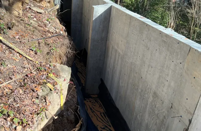 a concrete wall with a water pipe