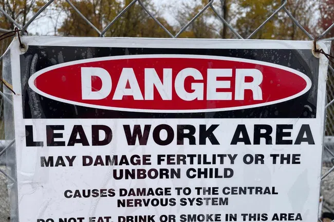 Danger sign warning of lead work area with health risks and instructions not to eat, drink, or smoke in the area.