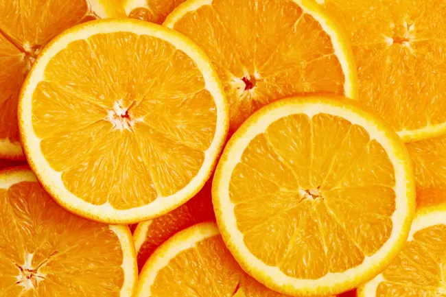 Close-up of multiple fresh orange slices showing juicy texture and vibrant color.