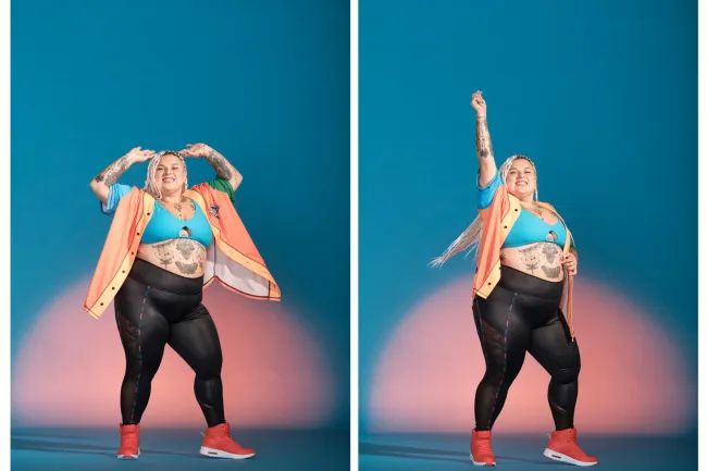Confident plus-size woman with tattoos posing in vibrant activewear against blue and pink background.