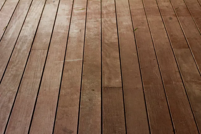 Close-up of a wooden deck with evenly spaced, parallel planks showcasing natural wood texture