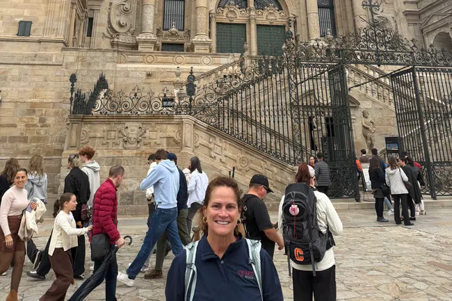 Tourists visiting the ornate facade of the historic Santiago de Compostela Cathedral in Spain.