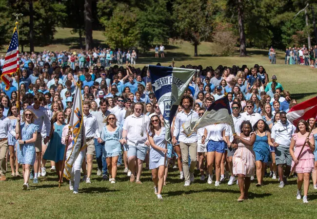 A vibrant crowd of students march together on a sunny day, showcasing school spirit and diversity.