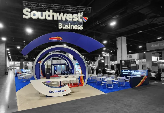 Southwest Business exhibition booth with circular blue arches and seating area at a trade show.