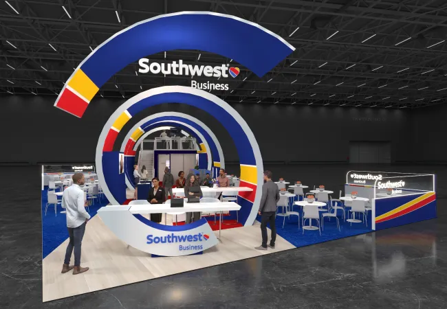 Southwest Business trade show booth with blue, red, and yellow circular design and seating areas in a convention center.