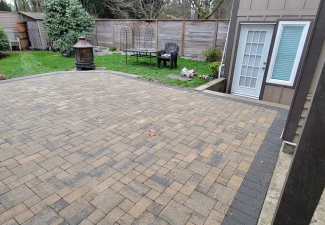 a brick patio with a fire hydrant and a house