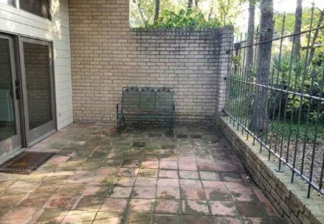 a brick patio with a metal gate