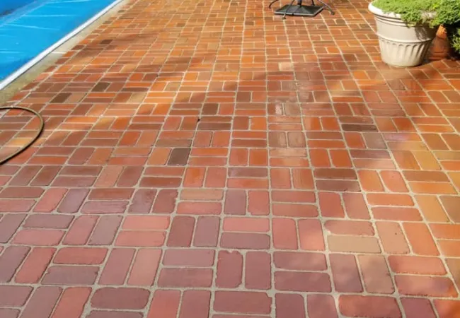 a brick patio with a table and a pool