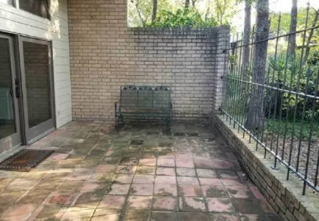 a brick patio with a fence and a brick building