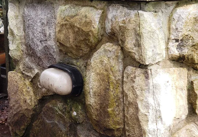 a stone wall with a metal cylinder on top