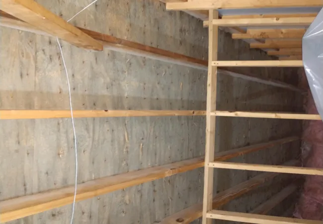 Interior view of wooden framing and insulation in an attic under construction or renovation