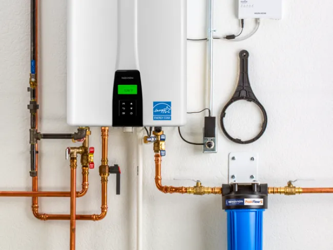 Modern tankless water heater installation with copper pipes and filtration system.