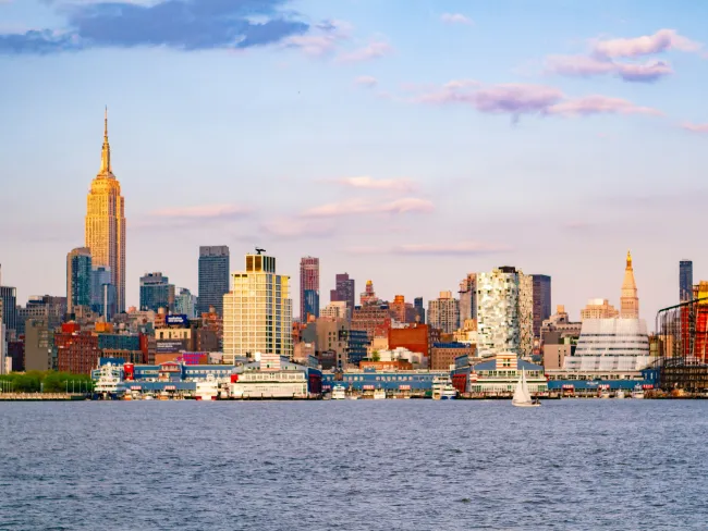 a city skyline with a body of water in the foreground