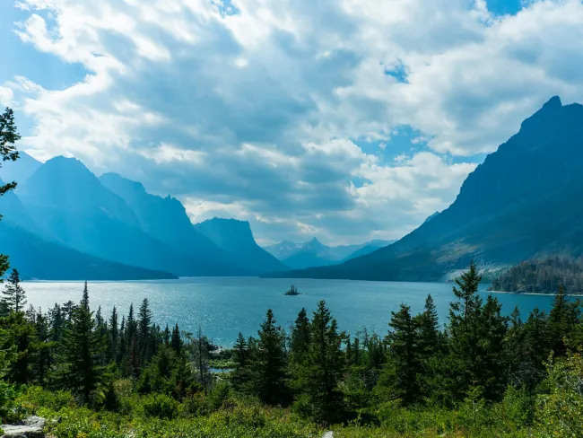 a lake surrounded by trees and mountains