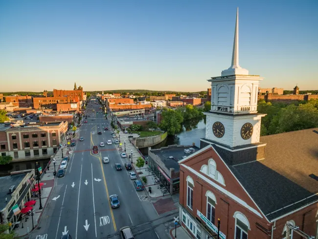 a large clock tower stands over a busy street