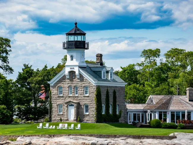 a large house with a light house with Mission Point Light in the background