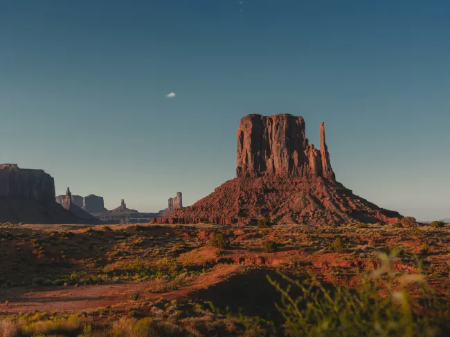 a rocky mountain with a moon in the sky