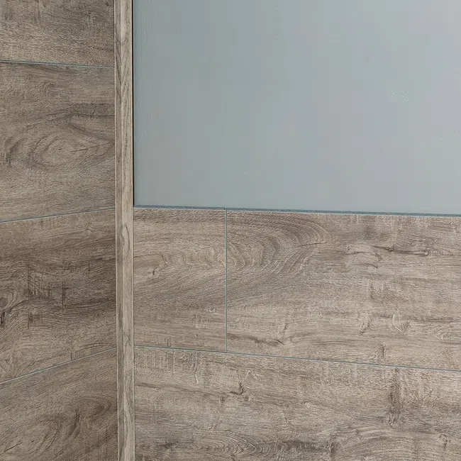 Corner wall covered with light brown wood-look tiles and upper portion painted light gray in modern interior.