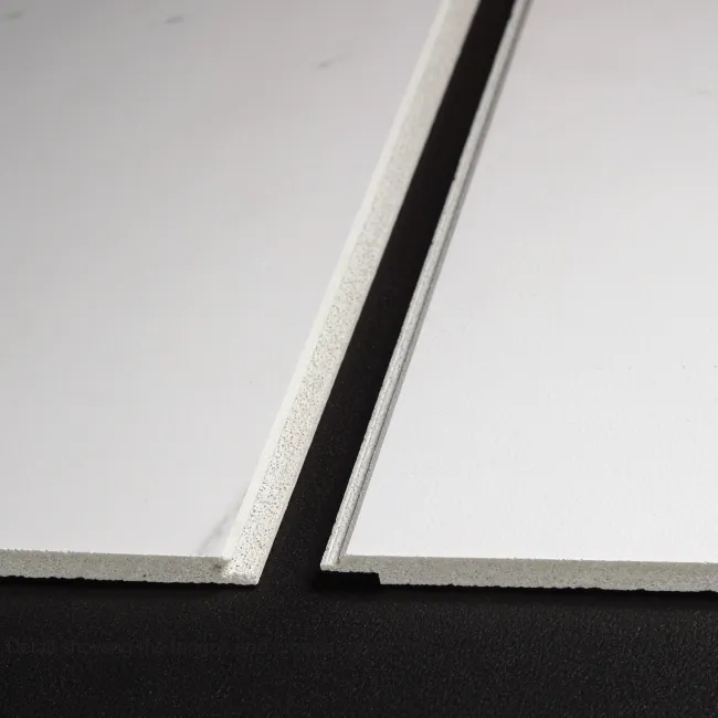 Close-up of two white gypsum ceiling tiles with different edge profiles on a black surface.