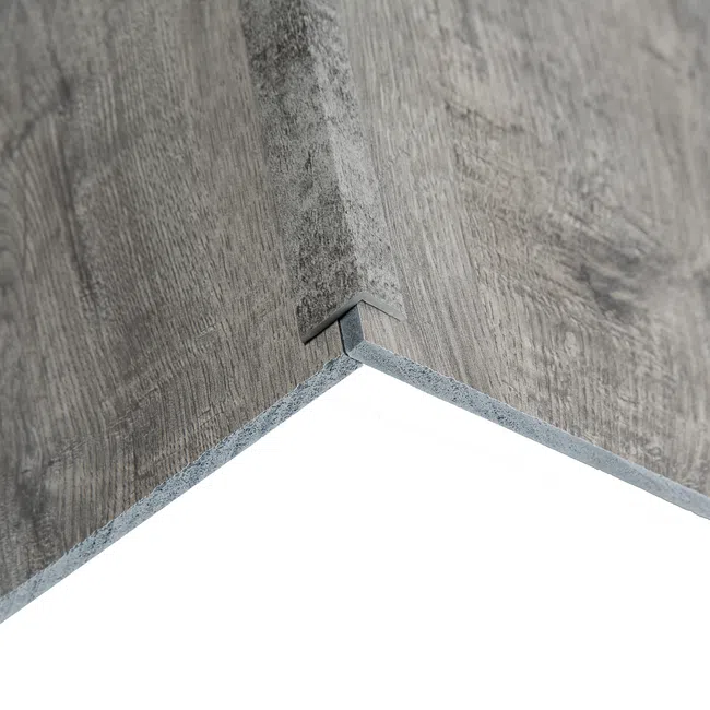 Close-up of interlocking gray wood-look laminate flooring panels with textured grain finish.