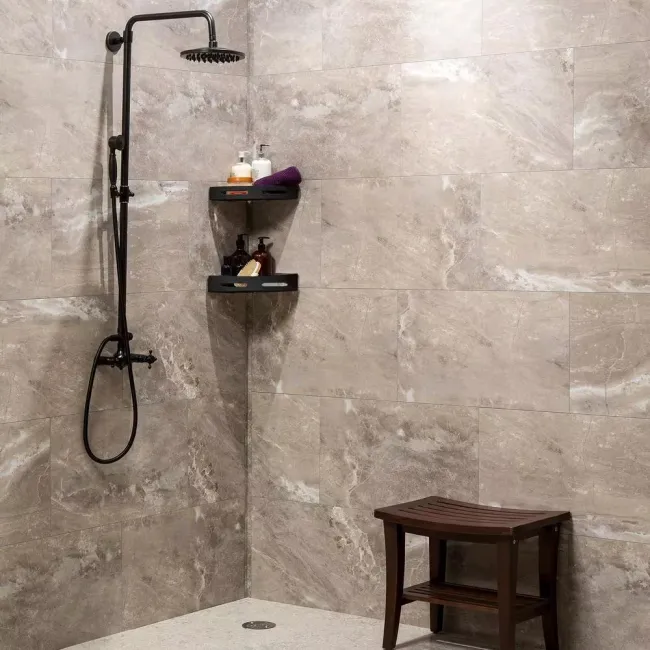 Modern walk-in shower with matte black fixtures, marble tile walls, corner shelves, and wooden shower stool.