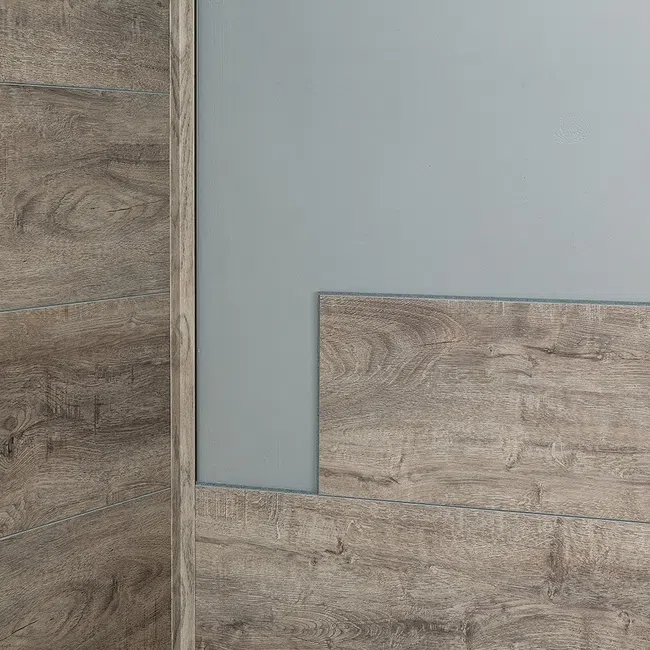 Close-up of rustic wood grain textured wall panels with gray painted wall corner indoors.