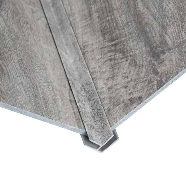 Close-up of gray wood textured vinyl flooring planks with interlocking edges on a white background