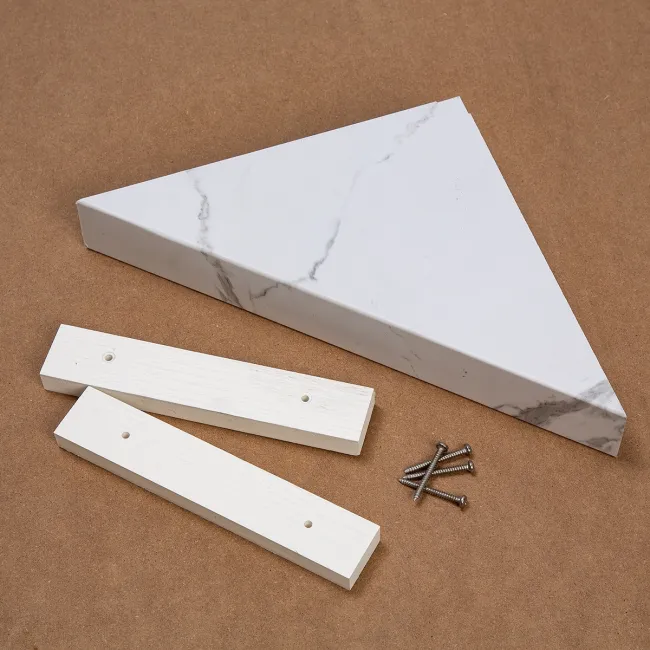 White marble triangular shelf with two white wooden mounting brackets and screws on brown background