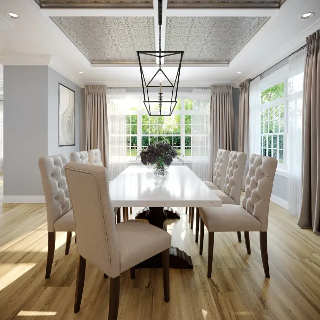Bright modern dining room with tufted beige chairs, white table, large windows, patterned ceiling, and central chandelier.