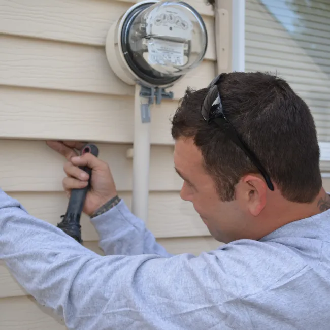 a man taking siding off a home