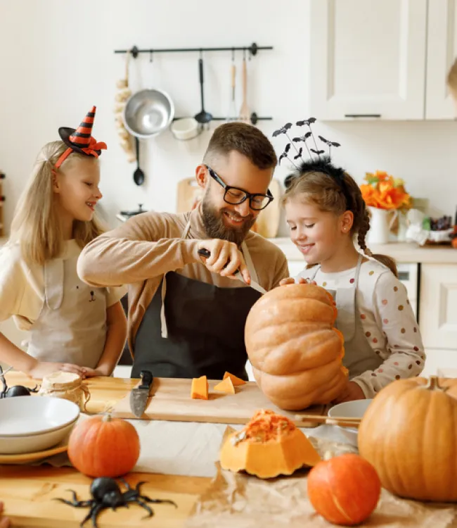 a group of people around a table with pumpkins in fall