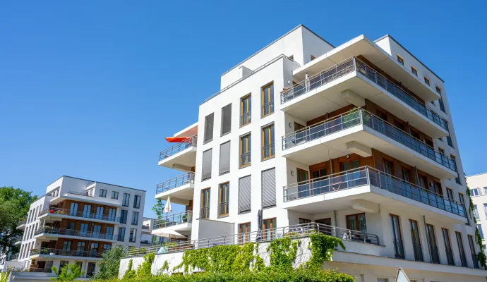 a building with balconies and trees in the front