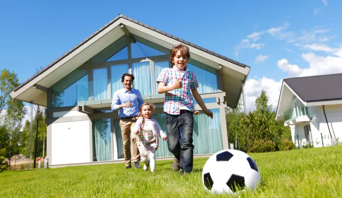 a family standing in front of a house with a football ball